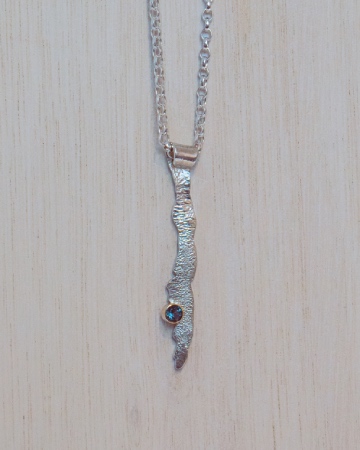 wavy long silver pendant set with a topaz